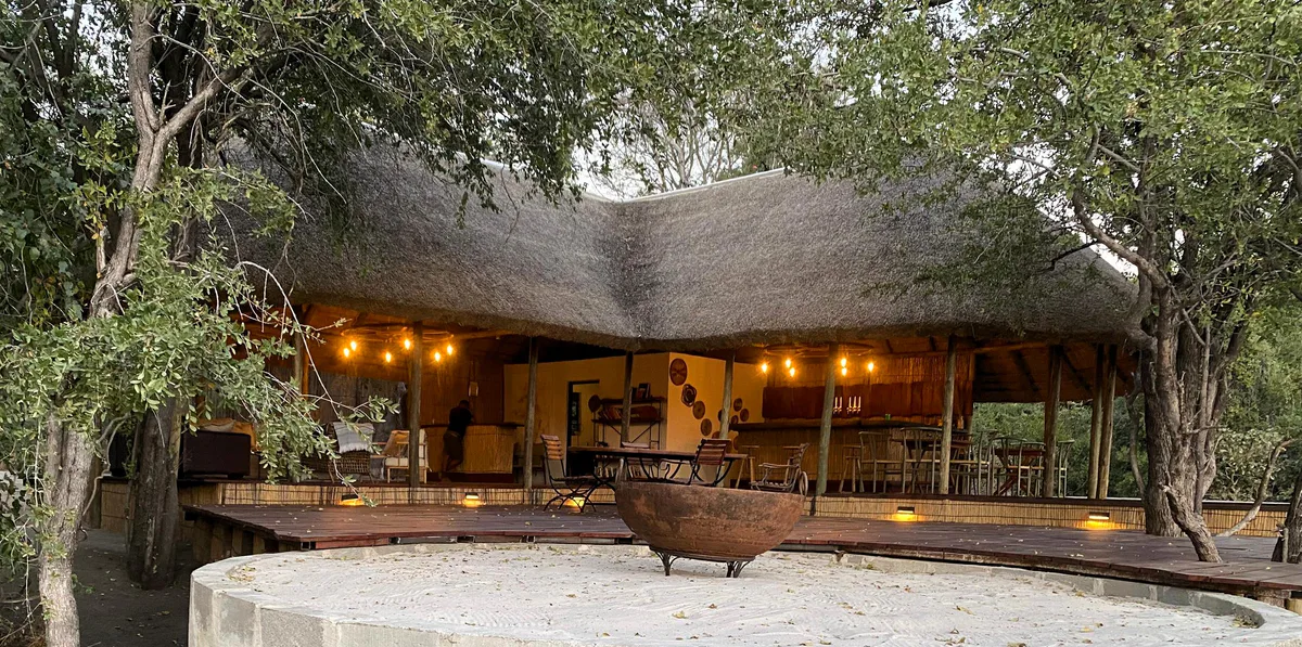 The thatched main area and deck beneath trees at Livingstone’s Camp.